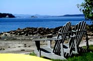 [Adirondak chairs and view of Little Deer Isle, Pumpkin Island lighthouse, and Camden.]